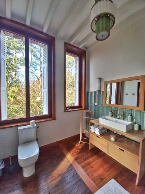 Modern bathroom at Villa Eliane in Étretat with wooden vanity, vessel sink, green tile accent wall, and garden views through