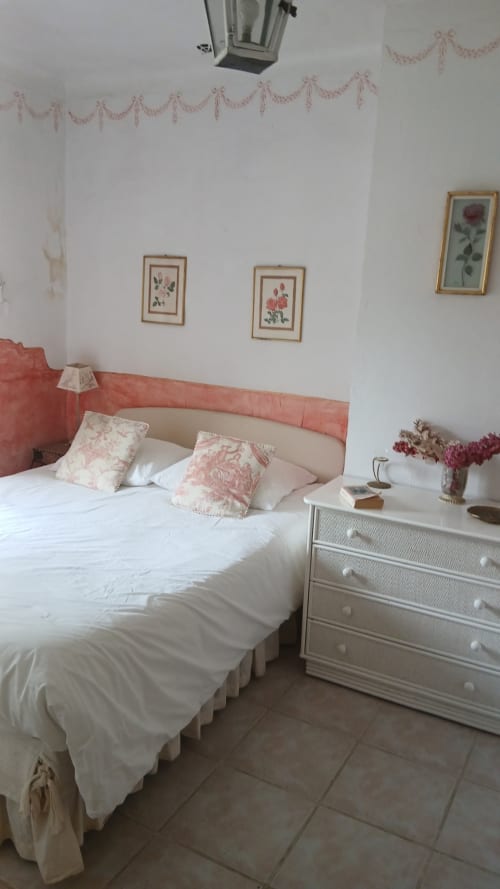 Élégante chambre double à La Ribeyrette B&B à Chamborigaud avec tête de lit corail, draps blancs, art botanique et décoration épurée