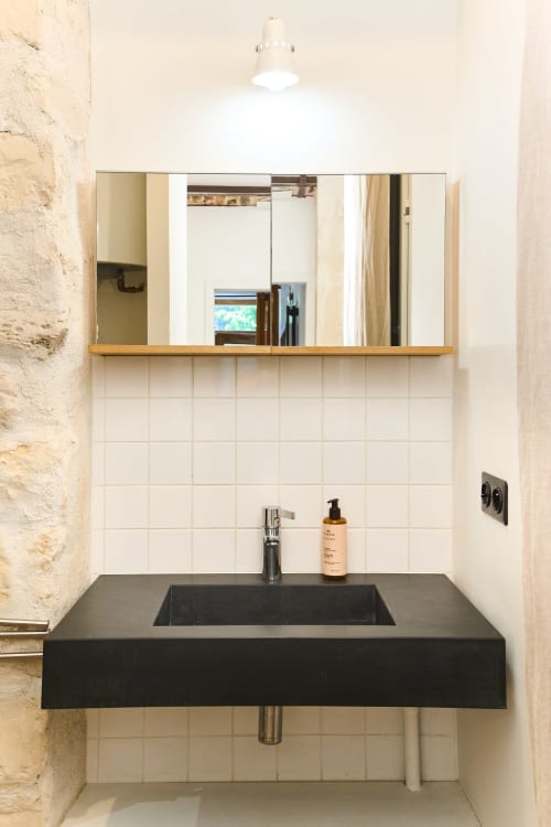 Lavabo noir moderne avec miroir et carrelage blanc au-dessus de l'évier dans la salle de bain du Loft Menilmontant chez Boutik Boheme, Paris