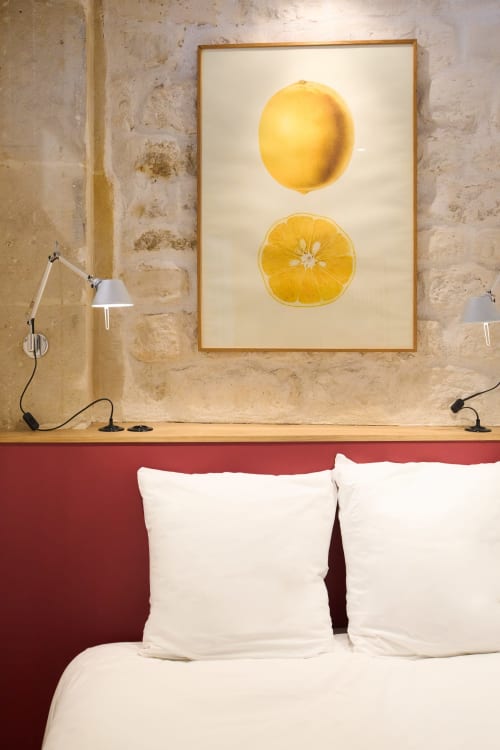 Loft Menilmontant chez Boutik Boheme Paris : chambre avec tableau citron, oreillers blancs, tête de lit rouge et lampe de lecture ajustable