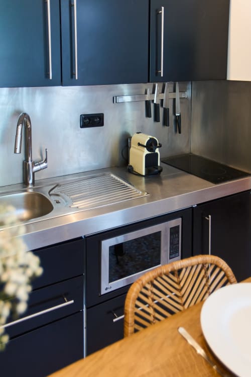 Kitchenette moderne au Loft Ménilmontant chez Boutik Bohème Paris avec électroménagers en acier inoxydable et mobilier foncé