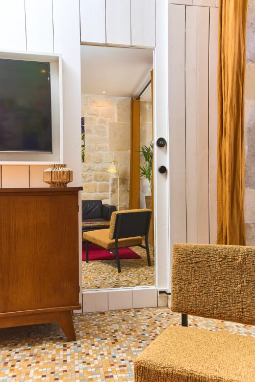 Entrée élégante d'un appartement parisien avec mobilier doré, carrelage en mosaïque et accès ouvert au salon chez Boutik Boheme