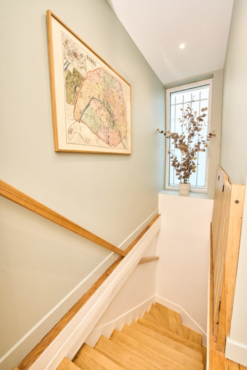 Escalier de l'appartement Le jardin Montmartre à Boutik Boheme, Paris, avec rampe en bois et carte vintage de Paris