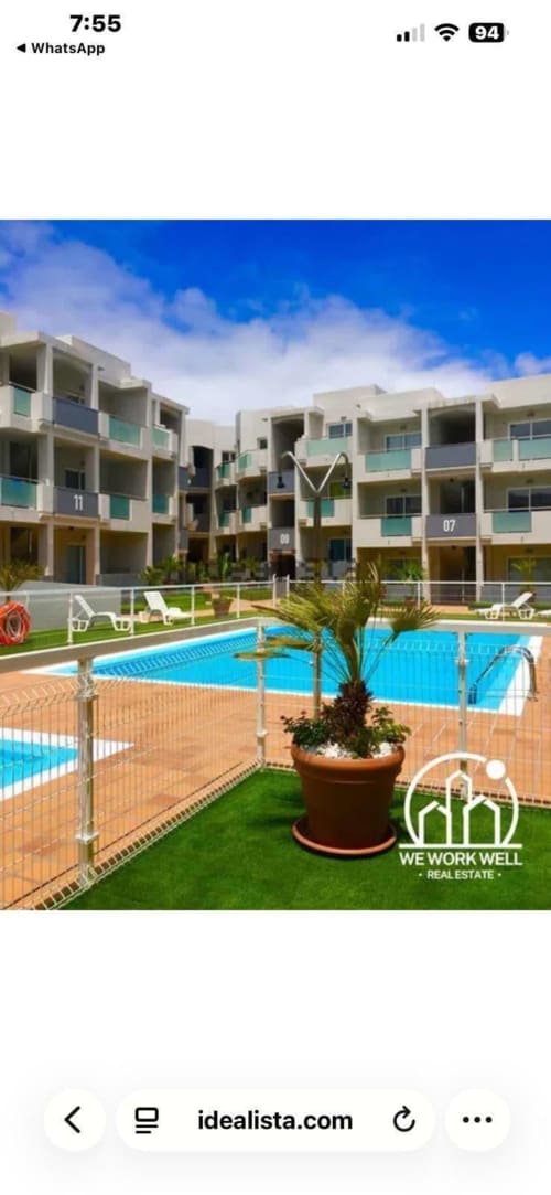 Complejo de apartamentos junto a la piscina de FTV Holidays Homes en La Oliva con arquitectura moderna y piscina azul