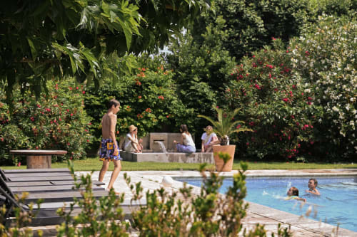Les clients se détendent à la piscine du Mas De La Digue avec ses jardins verdoyants et espaces de repos à Châteaurenard