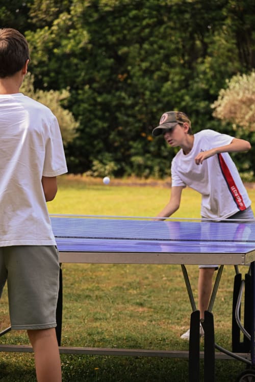 Deux garçons jouant au tennis de table en plein air au gîte Mas De La Digue à Châteaurenard, France