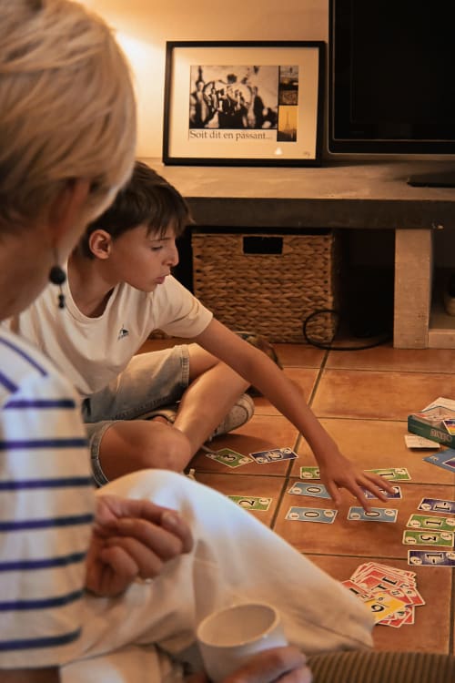 Enfant jouant aux cartes avec un adulte au Mas De La Digue B&B à Châteaurenard, France