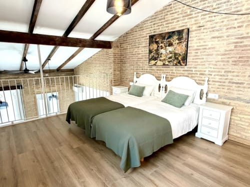 Dormitorio tipo loft moderno en Valencia con ladrillo visto, vigas de madera, dos camas, tragaluz y vistas a la ciudad en Stay Gest