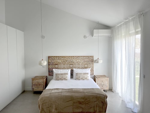 Modern bedroom with decorative carved wooden headboard, pendant lights, and sheer curtains at Casa Mareta villa in Bordeira,