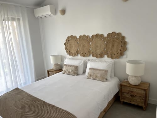 Bright bedroom in Casa Mareta villa, Bordeira, with white bedding, woven wall art, wooden nightstands, and coastal décor.