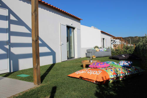 Casa Mareta villa in Bordeira with colorful outdoor cushions on green lawn and white-walled accommodation