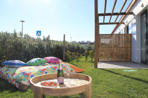 Colorful outdoor lounge at Casa Mareta villa in Bordeira with wine, snacks, and sea views