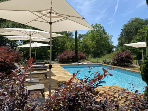 Baccara Lodge pool with lounge chairs, umbrellas, and landscaping in Arengosse