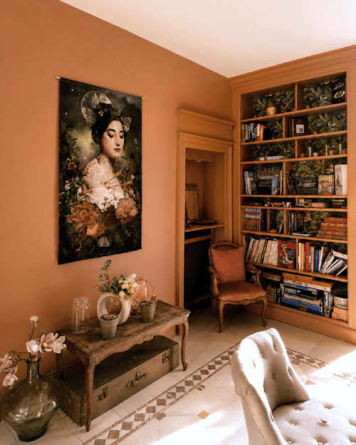 Warm terracotta room at Les Rives De La Tronne with portrait art, wooden shelving, and classic furnishings in Mer, France