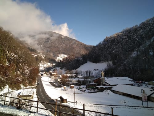 Vallée alpine enneigée avec les gîtes Les Boleros nichés entre les montagnes boisées de Queige, France