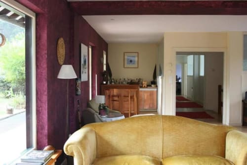 Elegant living room at Posada Torre del Milano in Comillas with burgundy walls, yellow sofa, and wooden furnishings