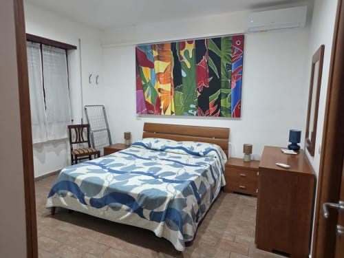 Camera moderna del Villargentina B&B a San Felice Circeo con biancheria blu decorata, mobili in legno e quadri colorati