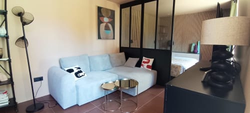 Studio moderne du Domaine Alga BnB avec canapé bleu clair, cloison noire et mobilier contemporain