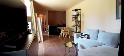 Modern living room at Domaine Alga B&B in Bourg-Charente with light blue sofa, desk, and open layout