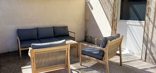 Terrasse du Domaine Alga B&B avec mobilier en bois et coussins bleu marine à Bourg-Charente