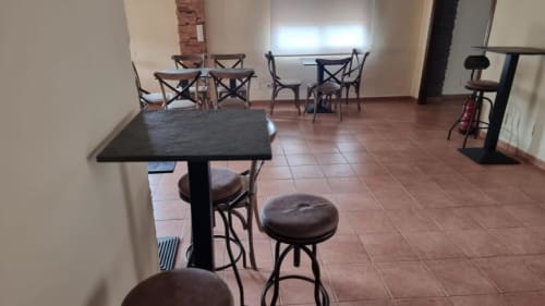 Amplio interior de villa en Finca El Arroyo con mesas de comedor, barra y piso de baldosas de barro en Alcaraz