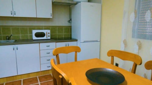 Cocina y comedor en villa de 2 dormitorios en Finca El Arroyo, Alcaraz con mesa de madera, sillas y cocineta equipada