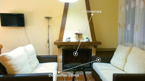 Sala de estar de la villa Finca El Arroyo en Alcaraz con chimenea, sofás cama, TV de pantalla plana y decoración
