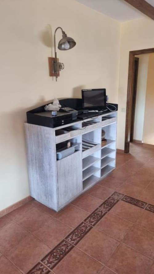 Escritorio de trabajo moderno con almacenamiento en estantes, configuración de laptop y lámpara colgante en villa Finca El Arroyo, Alcaraz