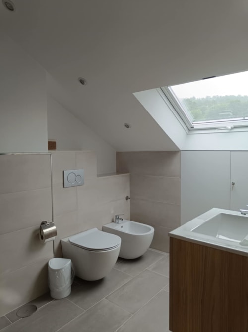 Moderno cuarto de baño en Avio Apartamentos Santiago de Compostela con inodoro, bidé, lavamanos y tragaluz