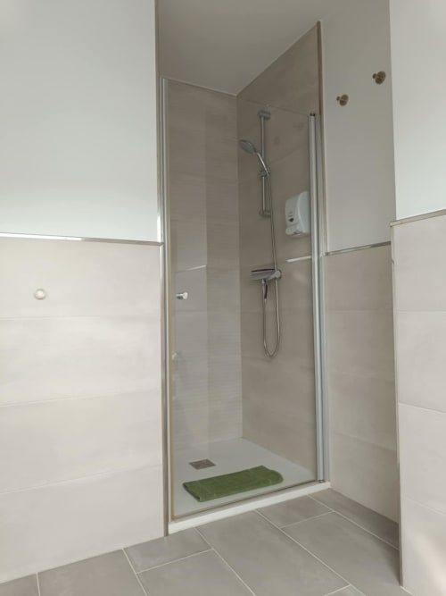 Ducha moderna con puertas de cristal y alcachofa de lluvia en Avio Apartamentos, Santiago de Compostela