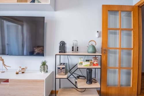 Modernes Küchenette im EcoHost Matosinhos Apartment mit Nespresso-Maschine, Wasserkocher und Lagerregalen