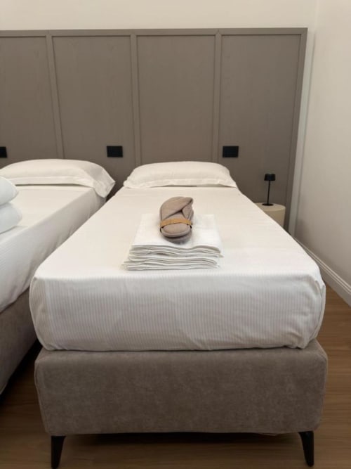 Due letti gemelli presso Maison Riviera B&B a Reggio di Calabria con lenzuola bianche e testata beige