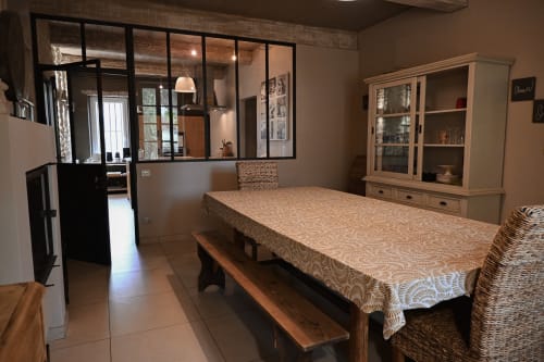 Salle à manger de la maison d'hôtes Mas De La Digue avec table en bois, cloison vitrée, meuble de rangement et mobilier neutre à Châteaurenard