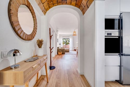 Corredor de apartamento moderno no Algarve com teto abaulado, detalhes em madeira e cozinha visível em AlgarStays