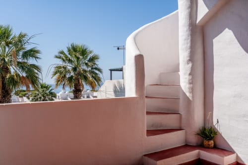 Escada rosa com vista para o mar no apartamento AlgarStays Algarve, palmeiras visíveis além da balaustrada do terraço