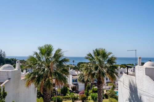 Les palmiers encadrent des appartements méditerranéens blancs avec vue sur la mer à Alporchinhos, Algarve