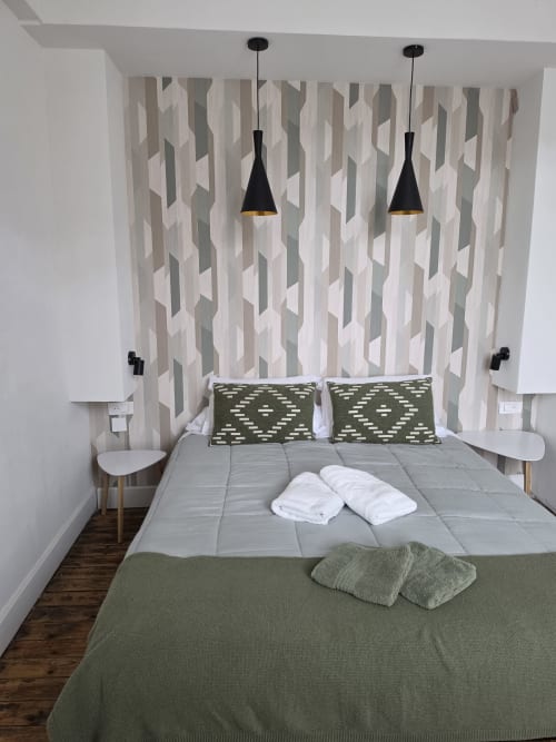 Modern bedroom at Gîte de la cité Tirlet, Chalons en Champagne, with geometric wallpaper and black pendant lights