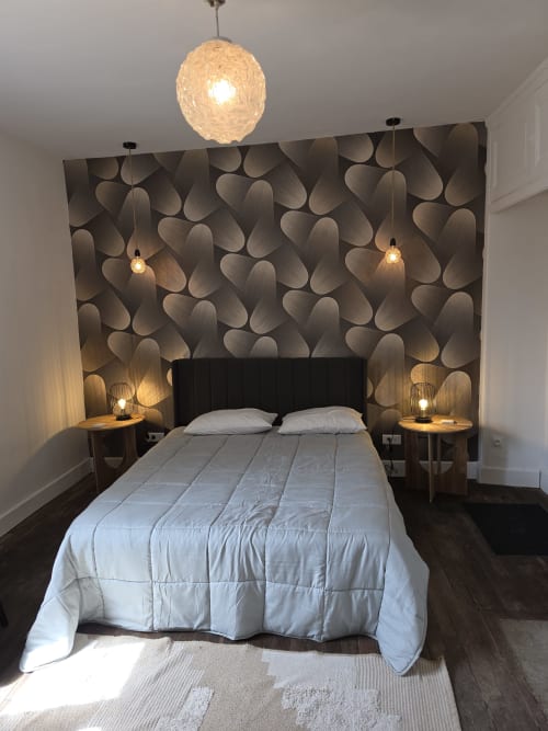 Modern bedroom at Gîte de la cité Tirlet in Chalons en Champagne with textured 3D wall, black headboard, white bedding,