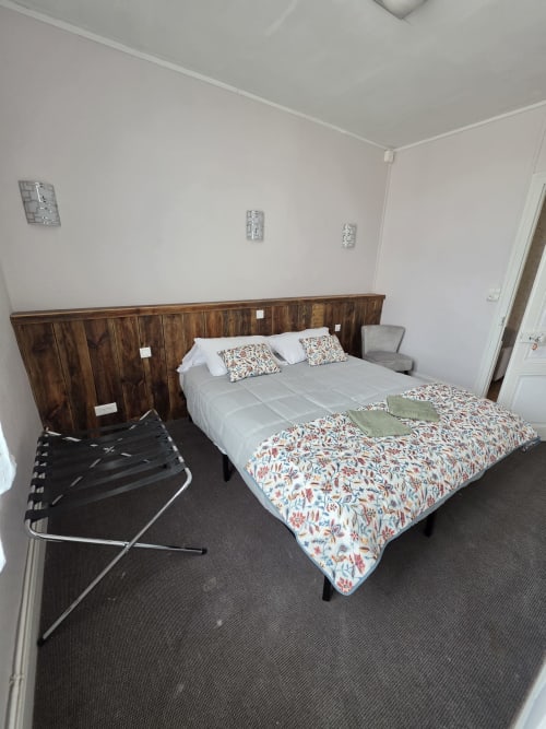Bright bedroom at STE CATALAUNES cottage in Chalons en Champagne with wooden headboard, floral bedding, and luggage rack