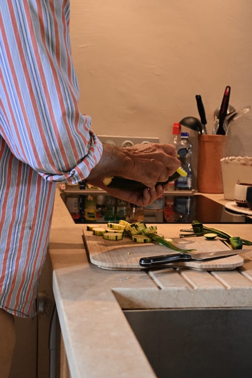 Chef préparant des poireaux tranchés au comptoir de la cuisine du Mas De La Digue à Châteaurenard, France