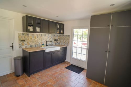 Cuisine moderne avec meubles sombres et carrelage à motifs de la villa Maison Héléna, propriété hellofamily à Lain, France