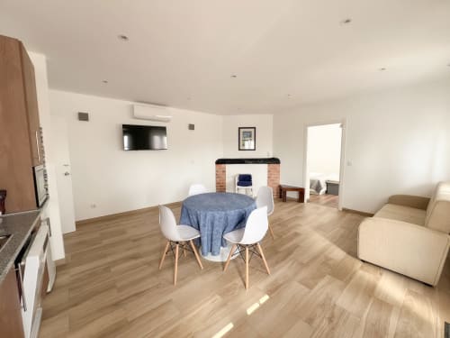 Apartamento T1 no rés-do-chão do Monte Horeb com mesa de jantar, sofá, TV e lareira em espaço aberto