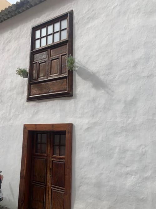 Fachada encalada del apartamento rural Casa 1820 en Santa Cruz de la Palma con puerta y ventana de madera oscura