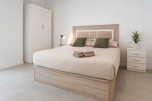 Estudio Doble Deluxe en Studios Sanchis Alicante con cama de madera, armario blanco y mobiliario moderno