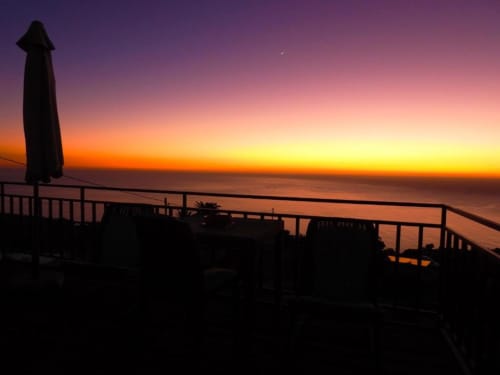 Terraza silueteada con sombrilla con vistas al espectacular atardecer marino en Villa Las Flores, La Palma
