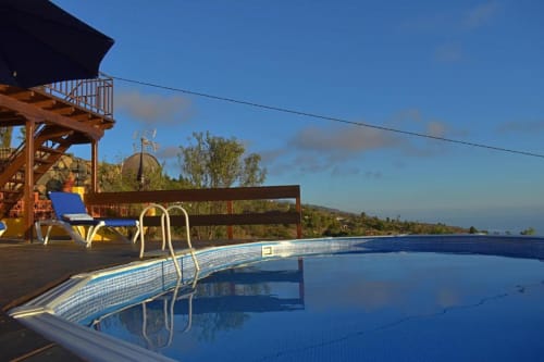 Piscina de Villa Las Flores con vistas al océano, Tijarafe, La Palma. Se aprecian tumbonas y terraza.