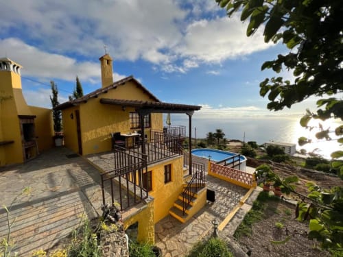 Villa Las Flores en Tijarafe, La Palma: arquitectura amarillo brillante con vistas al océano, piscina privada y terrazas