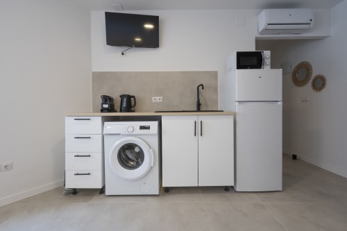 Cocineta moderna en Studios Sanchis Alicante con lavadora, refrigerador y electrodomésticos