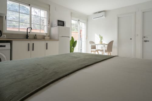 Moderna cocina estudio y zona de comedor en Studios Sanchis Alicante con acceso a terraza y vistas a la piscina
