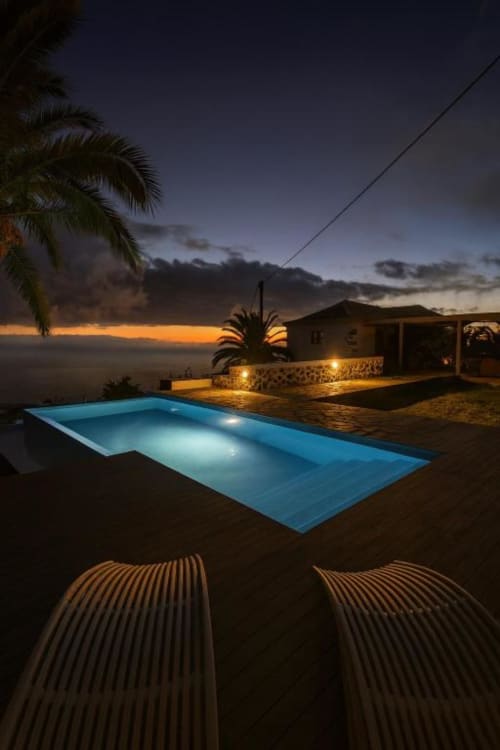 Piscina privada iluminada al atardecer con vistas al océano en villa Nexus, La Palma rural, Tijarafe